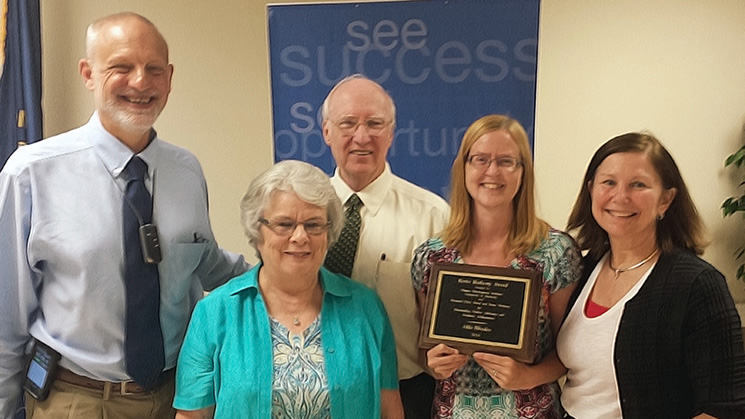 Allie Rhodes accepts award with the Burberrys and Doctor Harold Kleinert