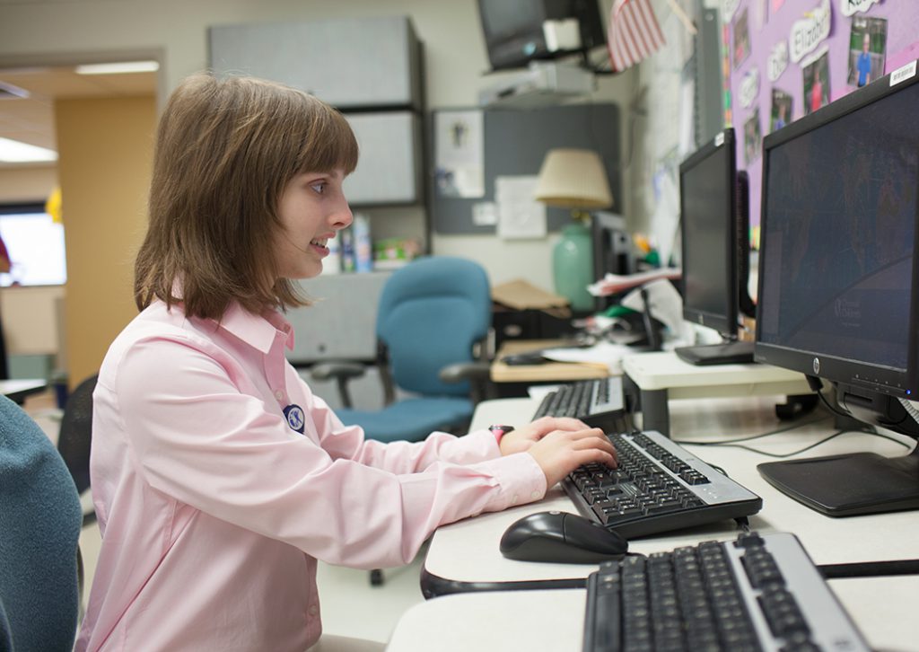 Young woman with a disability working at a computer.