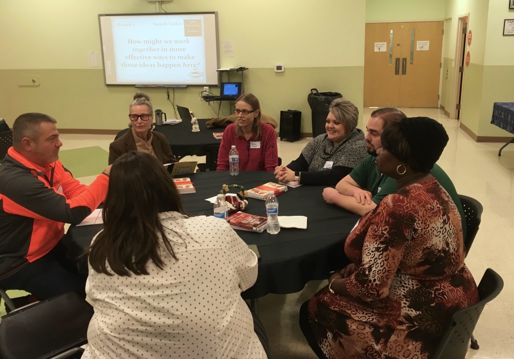 People sitting around a table at the community conversation.