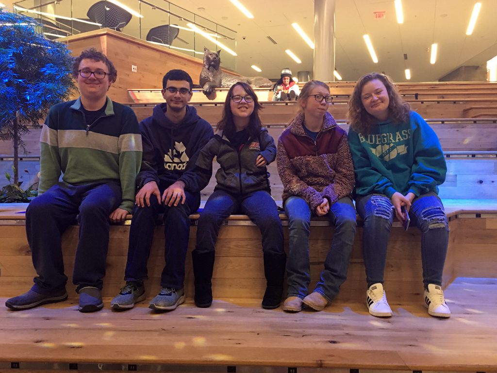 Five STEPS students sitting on a wall.