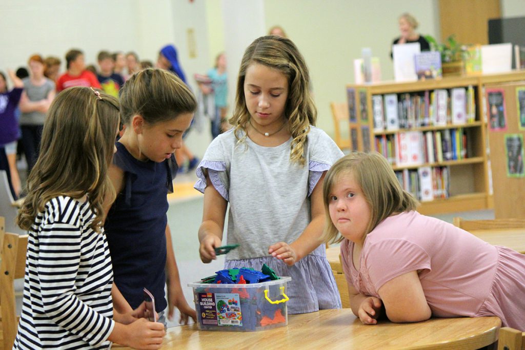 Four female students working together, including one with Down syndrome.