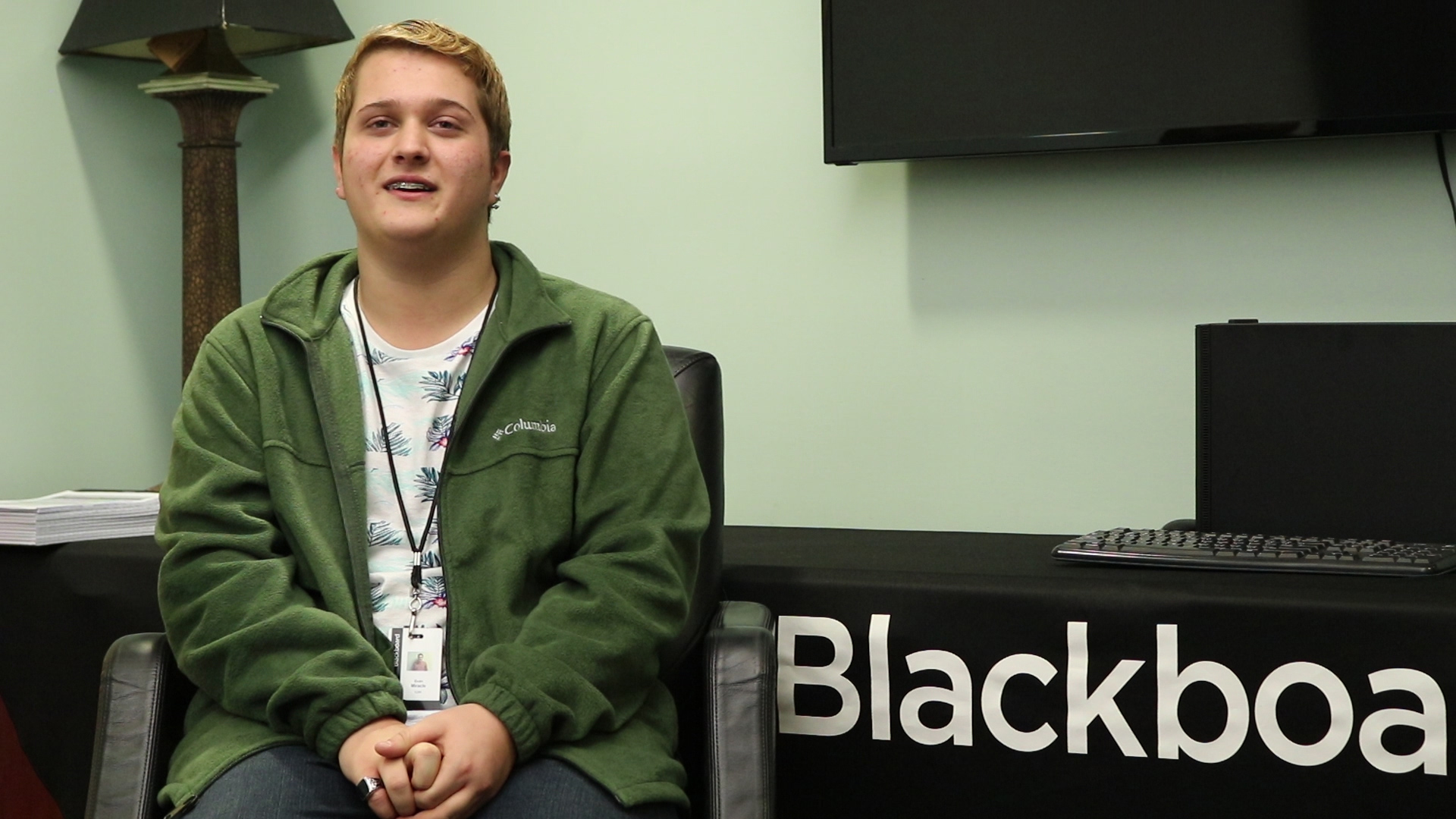 Evan Miracle sitting in a chair and smiling at camera