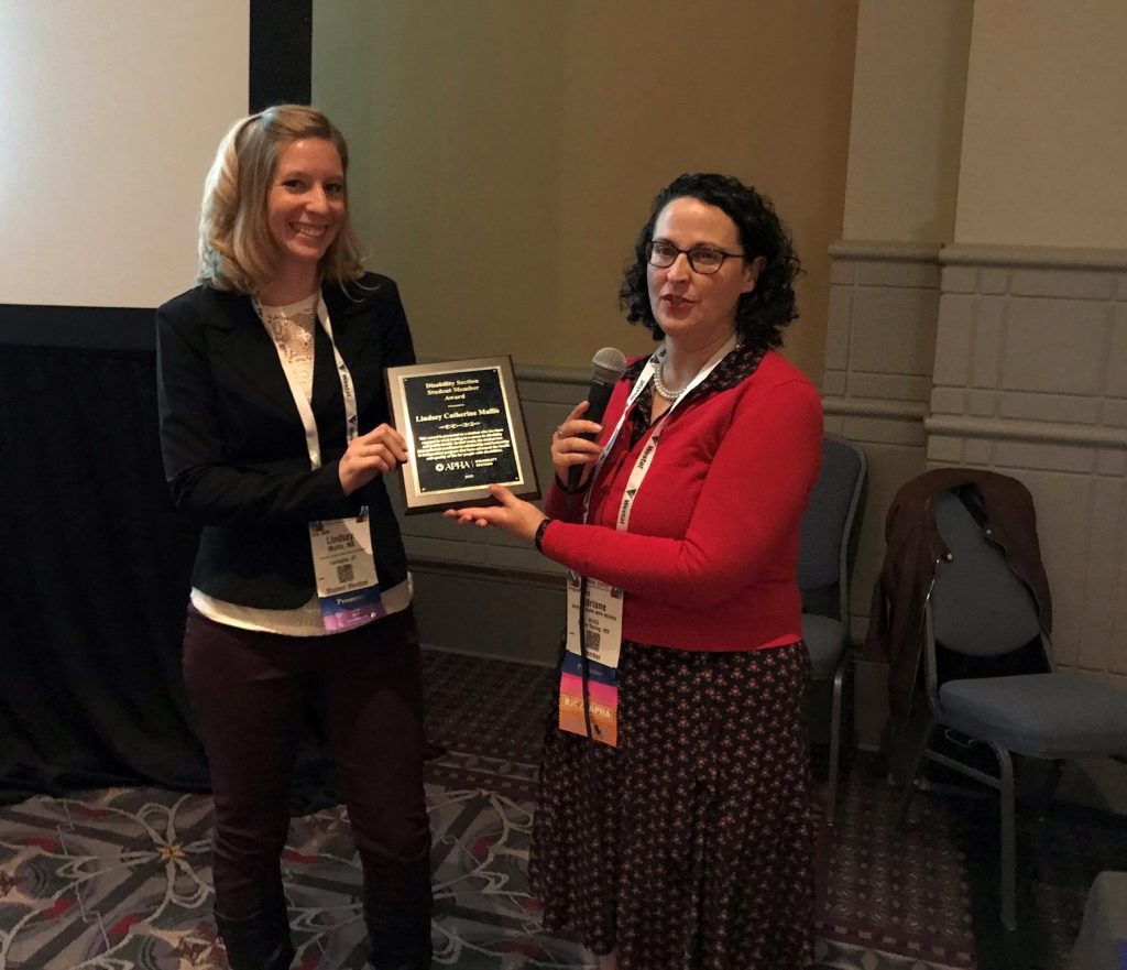 Woman receiving award from another woman