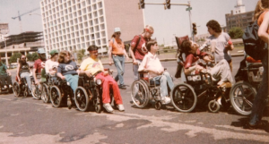 People using wheelchairs to move along the street in protest