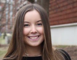 Ellie smiling in front of a red brick building