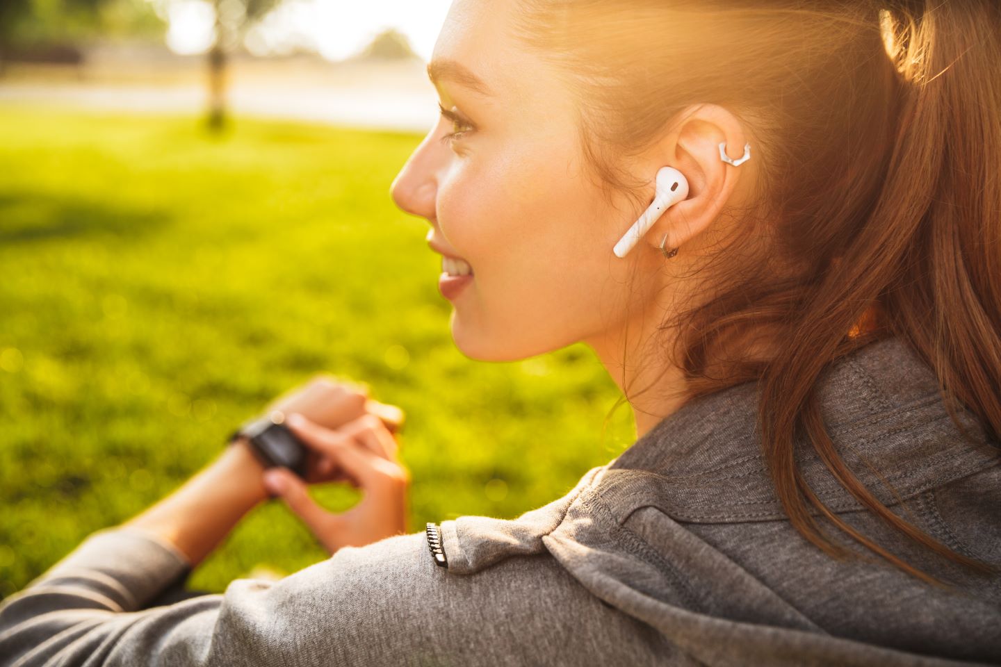 Woman using Airpods and touching Apple Watch