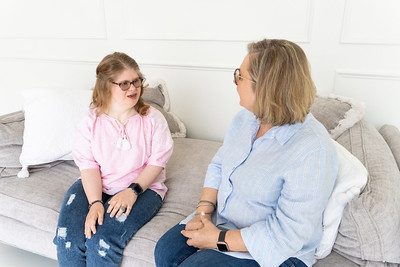 Two people seated on a couch talking